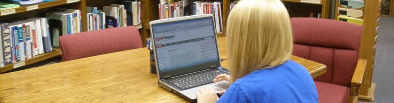 Photo of a student using a laptop to research scams.