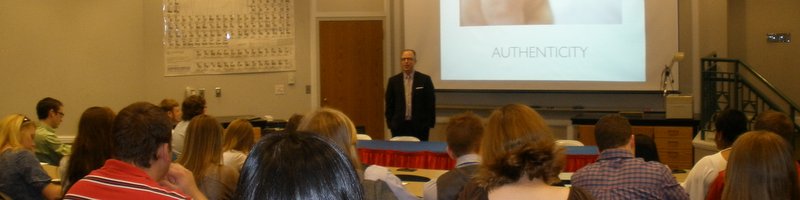 Photo of an alumnus speaking to a group of students.