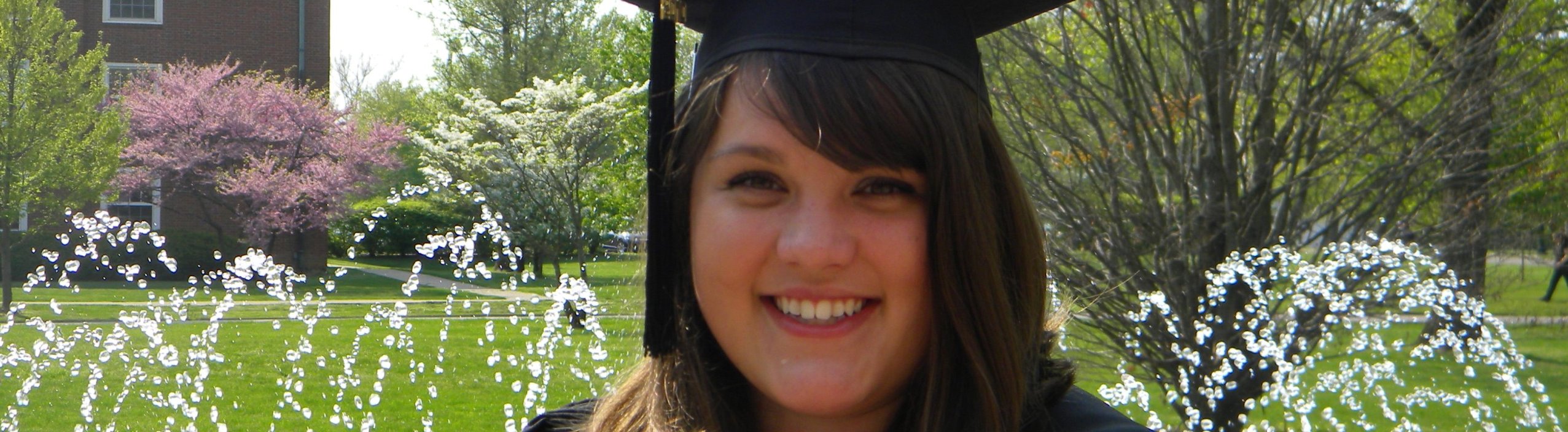 Photo of graduate in front of fountain