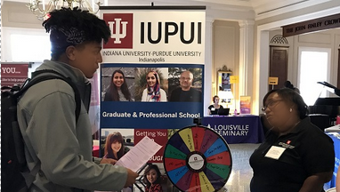 Photo of student speaking to recruiter at grad school fair.