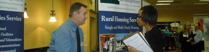 Photo of an African American student speaking to a recruiter at a career fair.